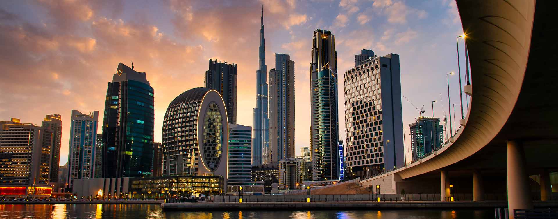 Aerial skyline panorama of modern skyscrapers in Dubai rising above the main city highway at sunrise