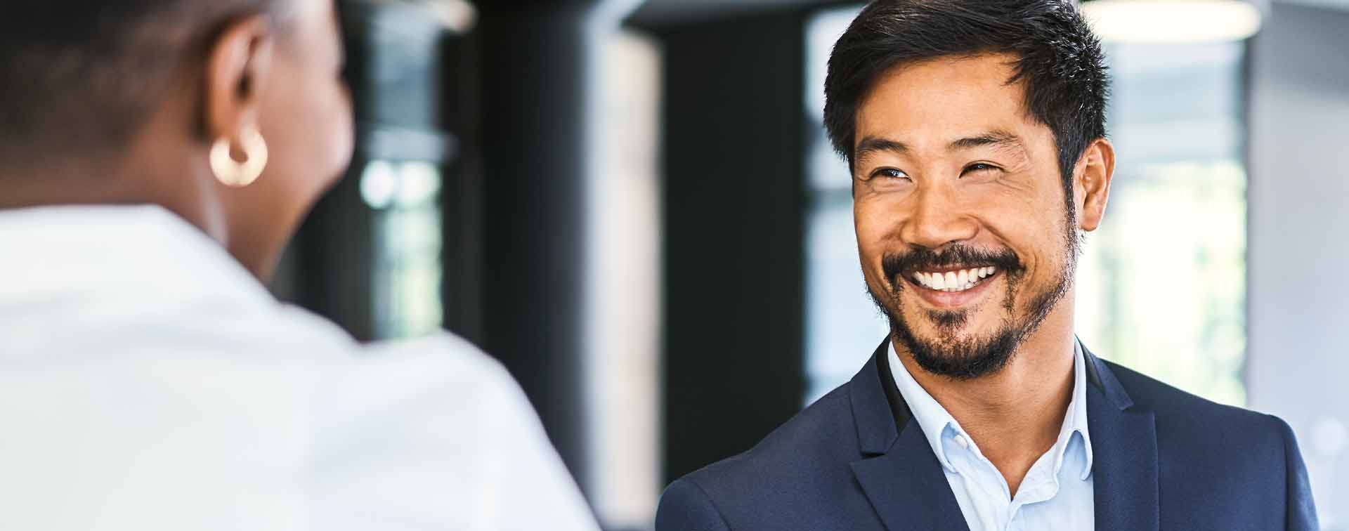 Smiling businessman greeting female professional 