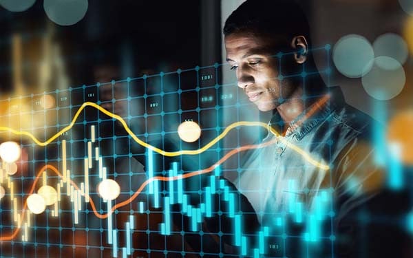 Digital composite of a man working on a tablet and a line graph