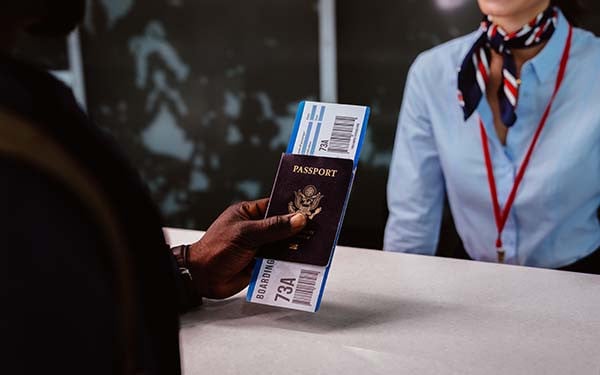 Traveler holding passport and boarding pass at an airport check-in counter