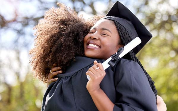 Two students hugging on graduation day