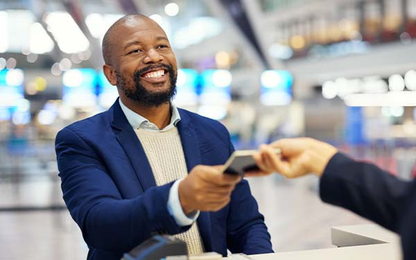 African man handing over passport before boarding his flight