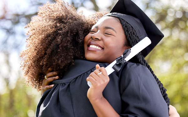 A young woman hugging her friend on graduation day 