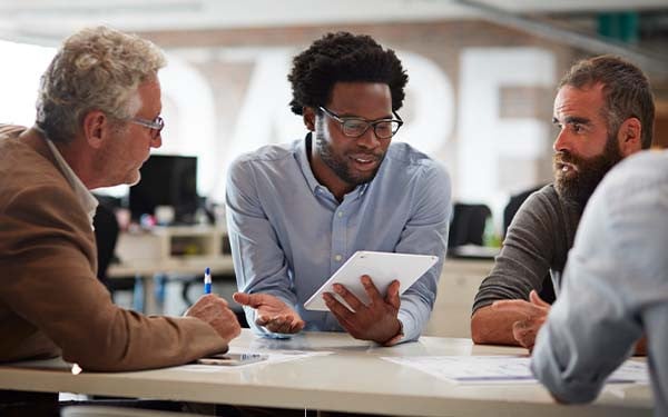 Businesspeople sitting around a table in discussion. 