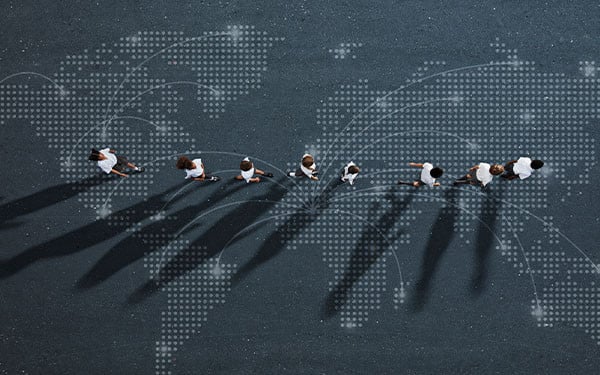 Abstract image of school children walking across a map of the world