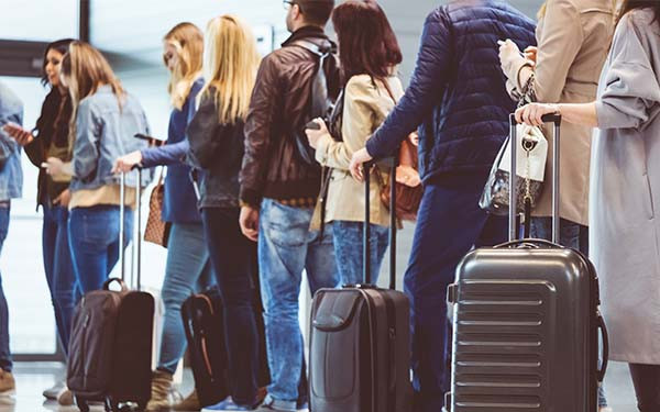 Queue of passengers waiting at boarding gate at airport. 