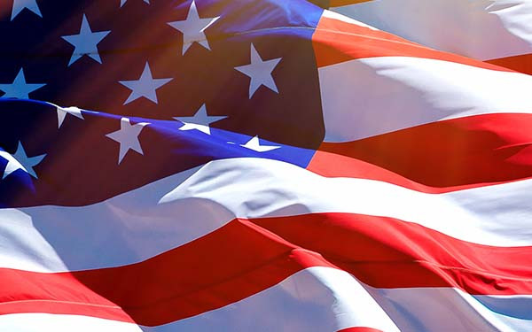 Large USA flag flying in the sunlight