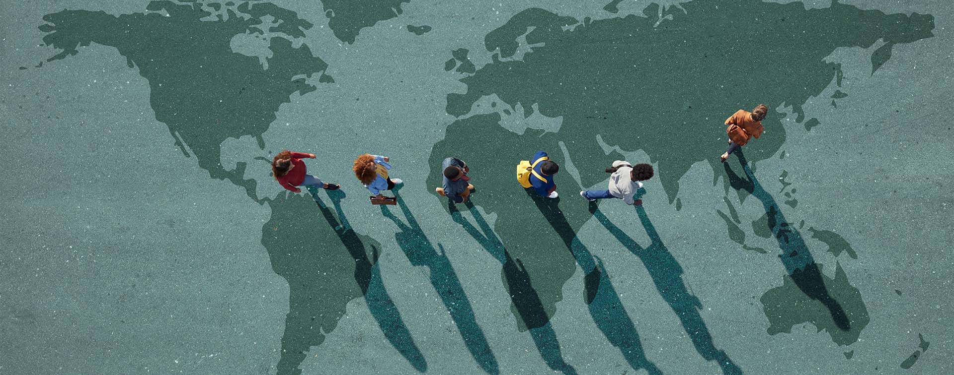 People walking in line across world map, painted on asphalt, front person walking left