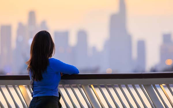Young woman overlooking Dubai skyline during sunset 