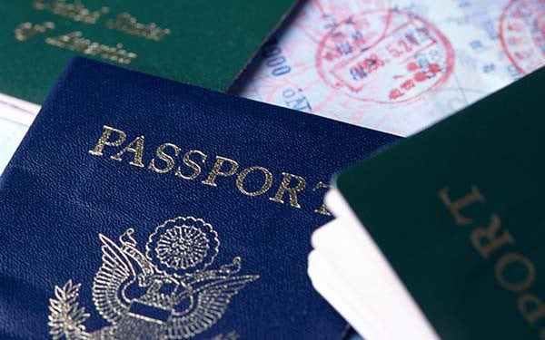American passports, green, blue, black on open page with visa stamps